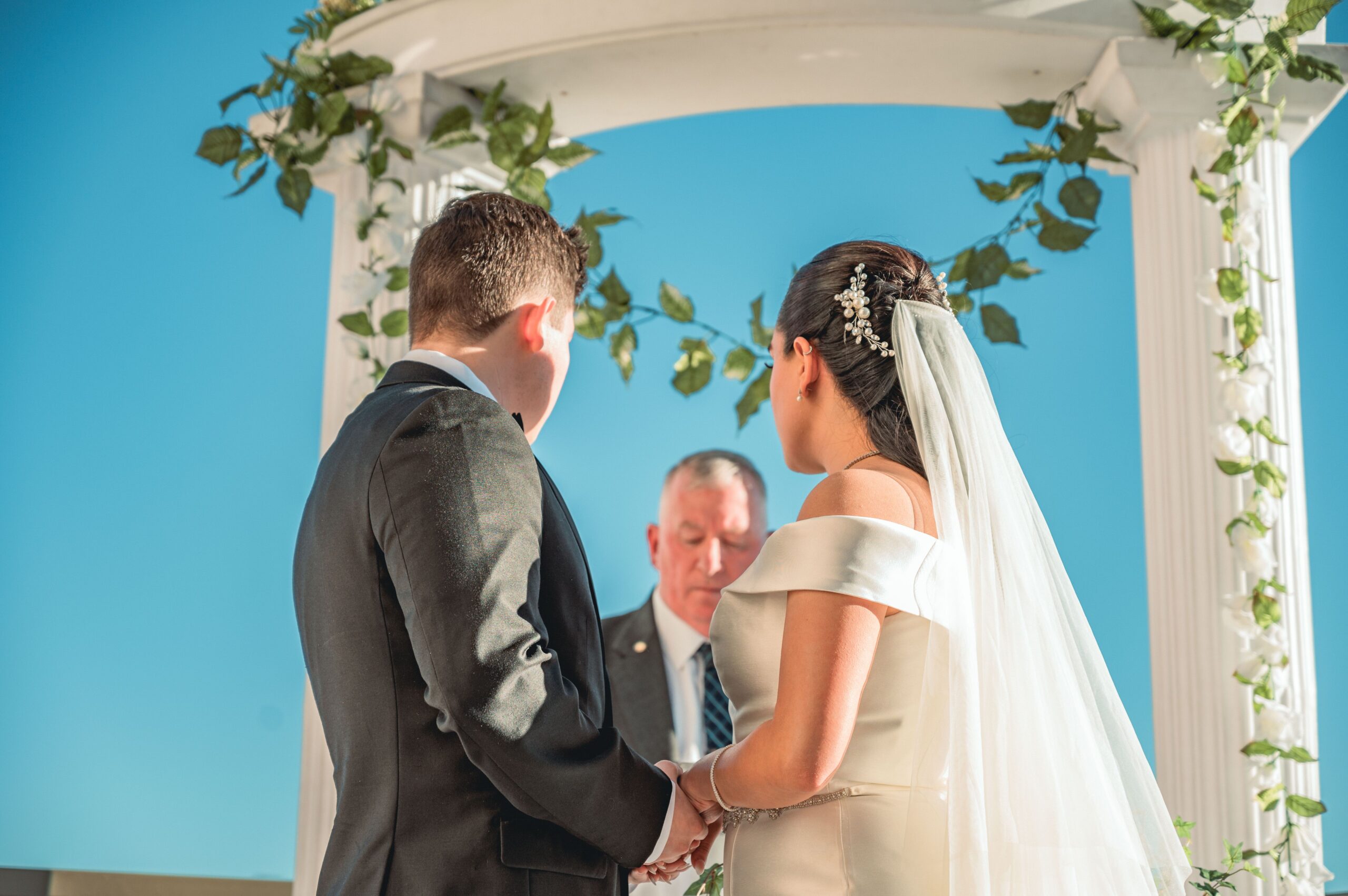 Mariés sous un arche fleuri lors d'une cérémonie de mariage en extérieur à Toulouse